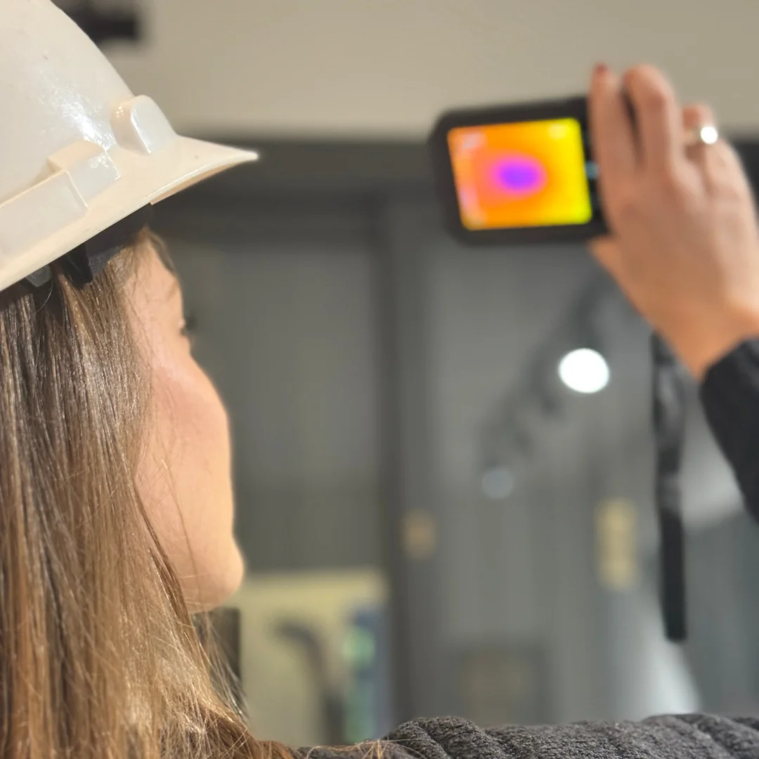 Engenheira utilizando câmera termográfica para análise de estrutura