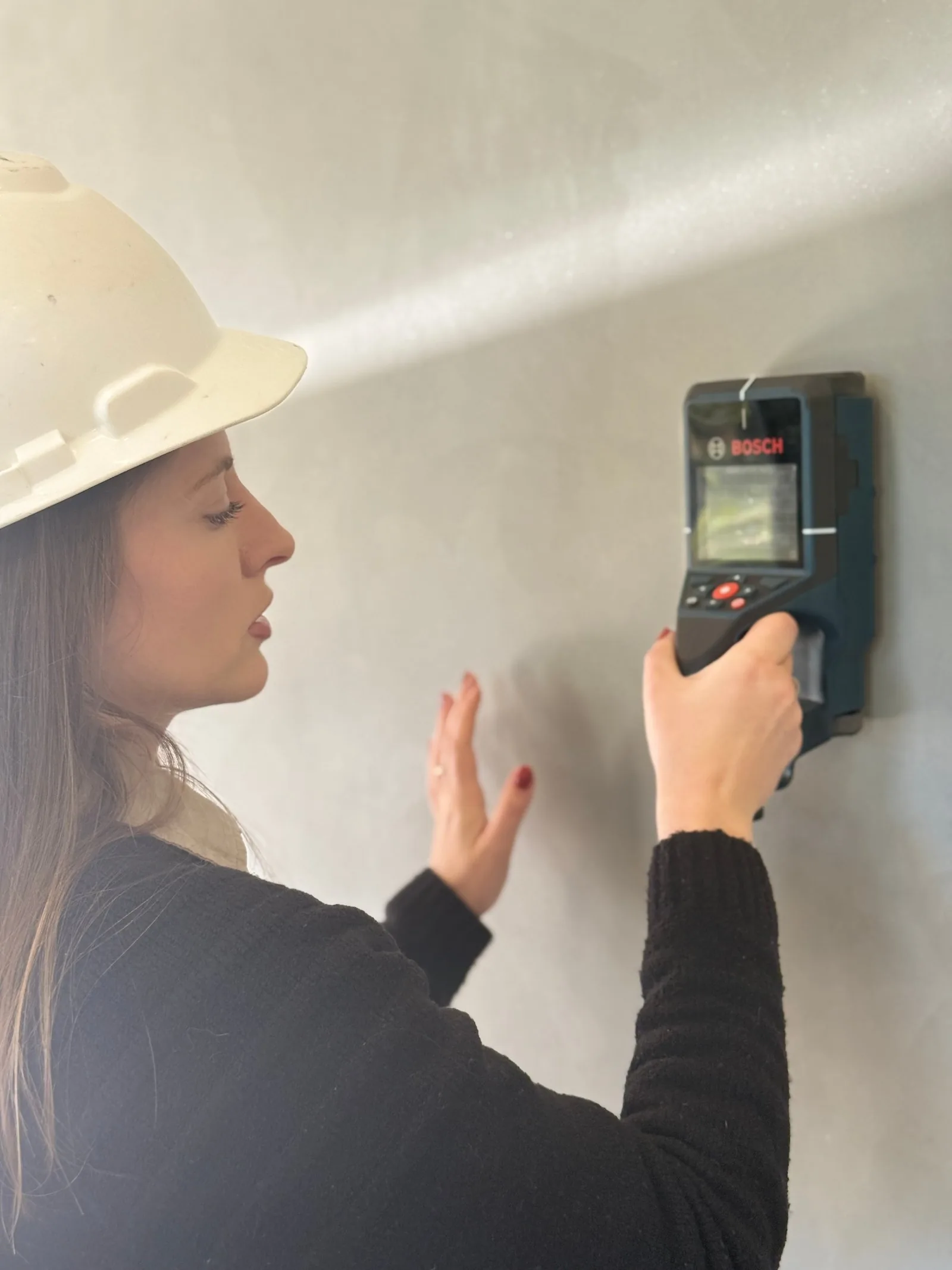 Engenheira utilizando um detector de parede profissional